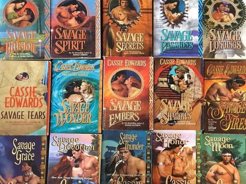 A collage photo of fifteen Cassie Edwards novels, every one of them featuring a heavily stereotyped, shirtless, Indigenous, American man and a somewhat less melanated woman. Hair flows, etc. Every single title features the word "Savage," e.g. "Savage Mission," "Savage Passions," and "Savage Honor."