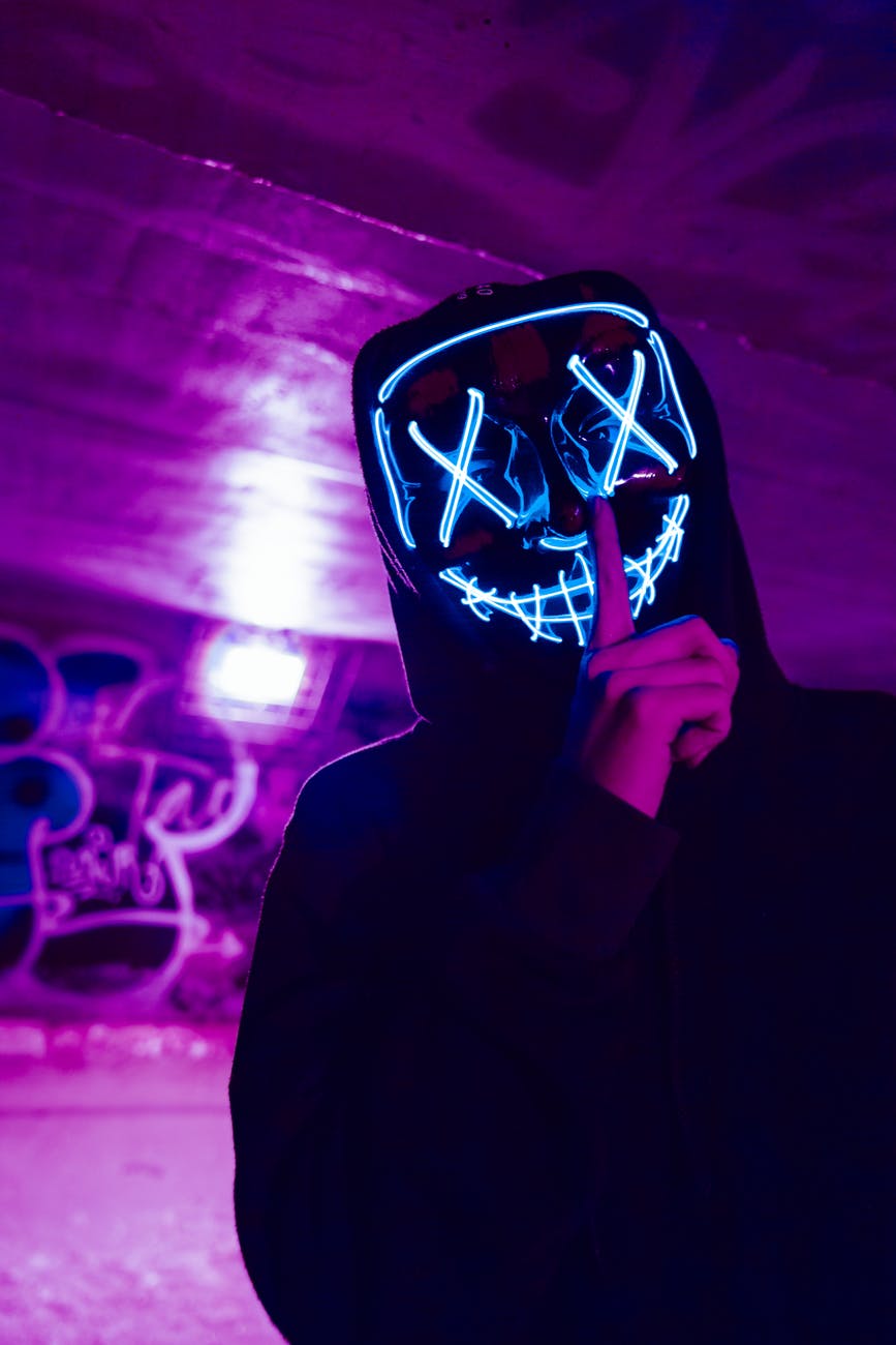 person wearing led mask doing silence gesture
